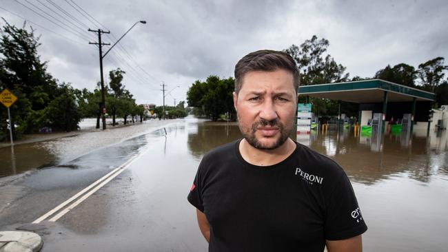 Restaurant owner Joseph Maruzza standing next to floodwater crossing the Cowpasture Bridge. On the opposite side of The Nepean River is his restaurant which was flooded. Picture: Julian Andrews