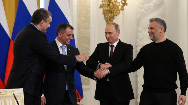 Vladimir Putin celebrates with Crimean premier Sergei Aksyonov, left, speaker of the Crimean legislature Vladimir Konstantinov, second left, and Sevastopol mayor Alexei Chalyi after the signing of a treaty in the Kremlin in March 2014 for Crimea to join Russia. Picture: AP