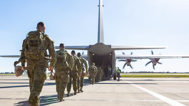 Members of the 1st Armoured Regiment, 1st Brigade board a C-130J Hercules at the RAAF Base Edinburgh.