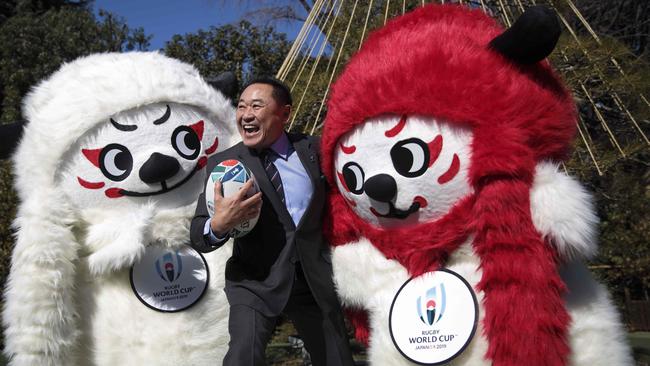 Former Japanese football player Yasutaro Matsuki poses with mascots Ren and G.
