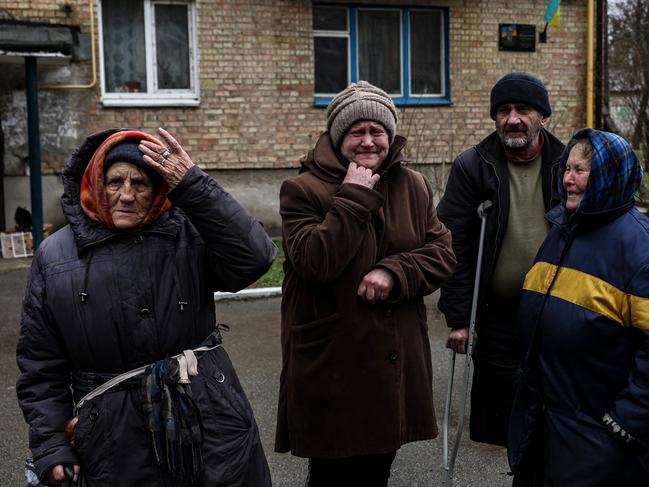 Women cry outside their houses in Bucha. Picture: AFP