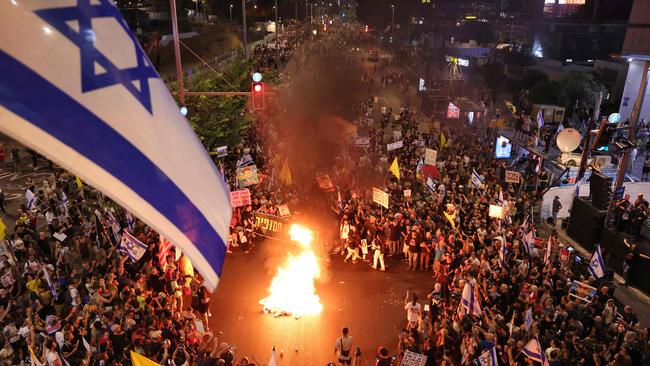 Demonstrators set a fire during an anti-government protest calling for action to secure the release of Israeli hostages. Picture: AFP.