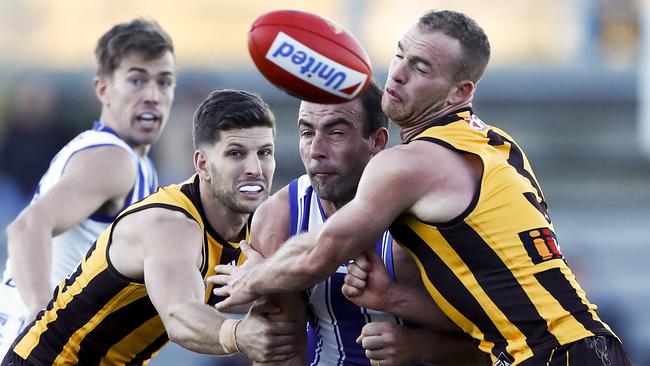 LAUNCESTON, AUSTRALIA - MAY 15: Ben Cunnington of the Kangaroos is tackled by Luke Breust and Tom Mitchell of the Hawks during the 2021 AFL Round 09 match between the Hawthorn Hawks and the North Melbourne Kangaroos at UTAS Stadium on May 15, 2021 in Launceston, Australia. (Photo by Dylan Burns/AFL Photos via Getty Images)