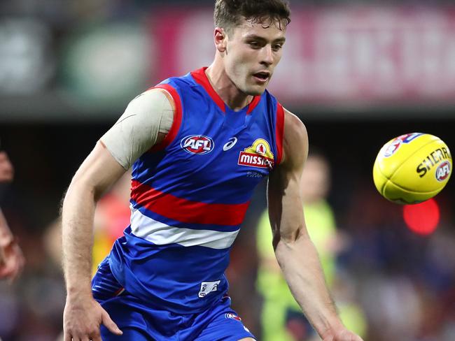 GOLD COAST, AUSTRALIA - JULY 17: Josh Dunkley of the Bulldogs looks to control the ball during the round 18 AFL match between Gold Coast Suns and Western Bulldogs at Metricon Stadium on July 17, 2021 in Gold Coast, Australia. (Photo by Chris Hyde/AFL Photos/via Getty Images)