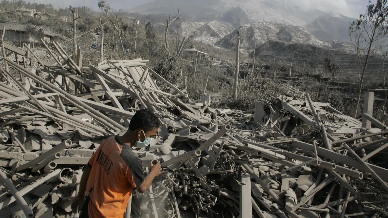 A rescue worker searches for victims in the debris of “Ring of Fire” volanic eruption.