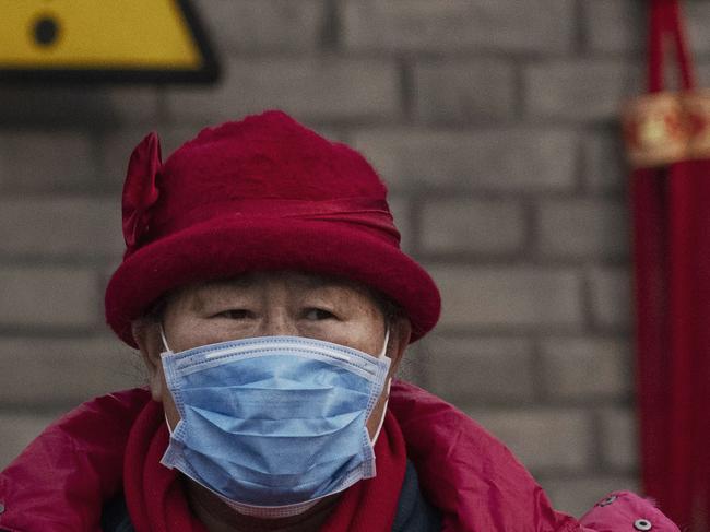 BEIJING, CHINA - JANUARY 27: A Chinese visitor wears a protective mask as she tour the grounds of the Temple of Heaven, which remained open during the Chinese New Year and Spring Festival holiday on January 27, 2020 in Beijing, China. The number of cases of a deadly new coronavirus rose to over 2700 in mainland China Sunday as health officials locked down the city of Wuhan last week in an effort to contain the spread of the pneumonia-like disease which medicals experts have confirmed can be passed from human to human. In an unprecedented move, Chinese authorities put travel restrictions on the city which is the epicentre of the virus and neighbouring municipalities affecting tens of millions of people. The number of those who have died from the virus in China climbed to at least 80 on Monday and cases have been reported in other countries including the United States, Canada, Australia, France, Thailand, Japan, Taiwan and South Korea.Due to concerns over the spread of the virus, the Beijing government closed many popular attractions such as the Forbidden City and sections of the Great Wall among others. (Photo by Kevin Frayer/Getty Images)