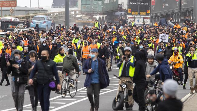 Protesters form up into a large group as they return down the West Gate Bridge to a large unit of riot police on Tuesday. Aaron Francis/The Australian