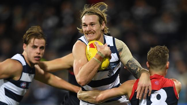 Geelong’s Tom Stewart breaks the tackle of Melbourne Demon’s Jake Melksham at Kardinia Park Stadium in Geelong. Picture: Julian Smith/AAP