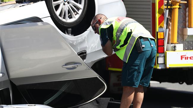 Paramedics check on a car that rollover on the Gold Coast Highway. Photograph : Jason O'Brien