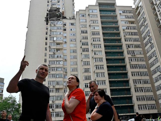 TOPSHOT – Kyiv's Mayor Vitali Klitschko talks with local residents next to a 24-storey building partially destroyed following a Russian missiles strike in Kyiv early on June 24. Picture: Sergei CHUZAVKOV / AFP