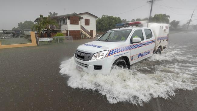 Police make their way through the flooded streets of Townsville. Picture: Glenn Hunt 