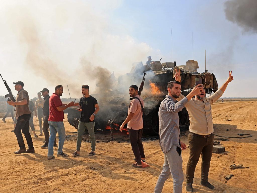 Palestinians take control of an Israeli tank after crossing the border fence with Israel from Khan Yunis in the southern Gaza Strip. Picture: AFP