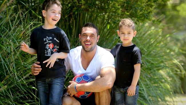 Ben Hoad with sons Calyn (8) and Kya (5) from Beenleigh, having fun with a football. Calyn suffered serious head injuries when he was hit by a car in 2013. Pic Mark Cranitch.