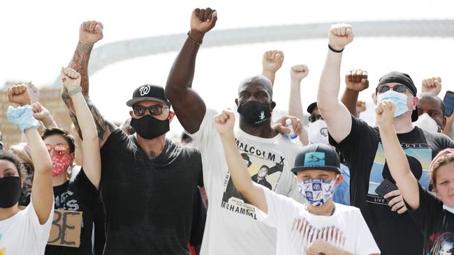 Actor Dave Bautista, left, and WWE wrestler Titus O'Neil take a group photo with supporters during the ‘Love Walk’ on Saturday in downtown Tampa, Florida. Picture: Getty Images