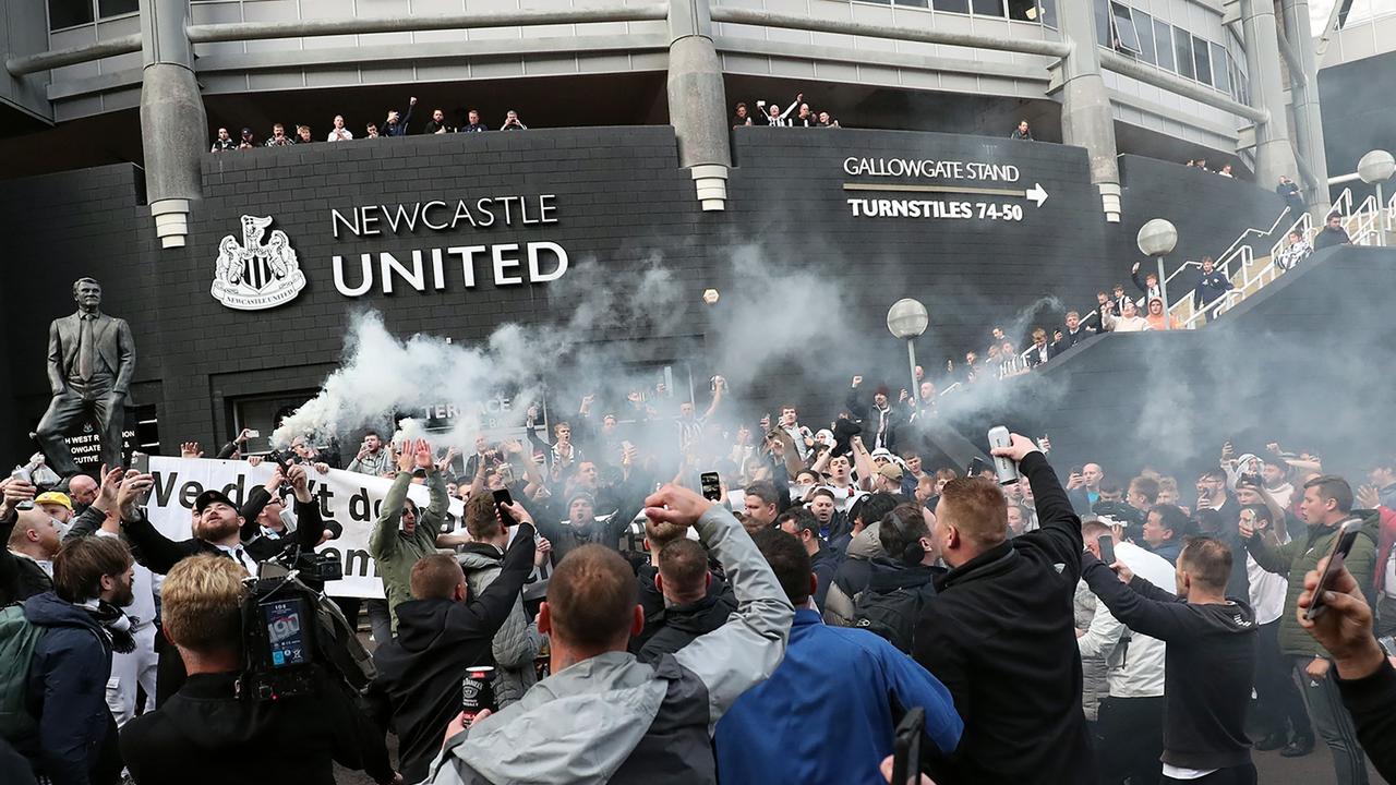 Newcastle United supporters celebrate outside the club's stadium St James' Park in Newcastle upon Tyne in northeast England on October 7, 2021, after the sale of the football club to a Saudi-led consortium was confirmed. - A Saudi-led consortium completed its takeover of Premier League club Newcastle United on October 7 despite warnings from Amnesty International that the deal represented "sportswashing" of the Gulf kingdom's human rights record. (Photo by - / AFP)