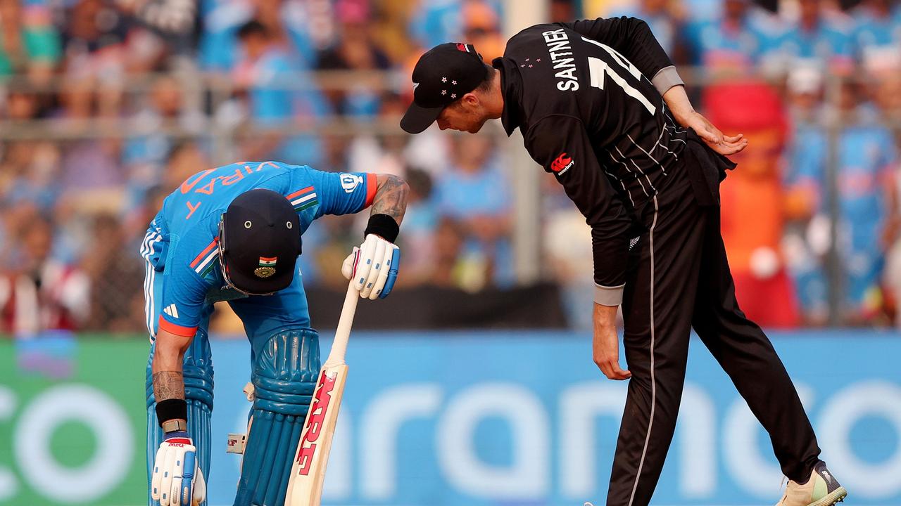 New Zealand’s Mitchell Santner checks on Virat Kohli as he stretches out a cramp. (Photo by Robert Cianflone/Getty Images)