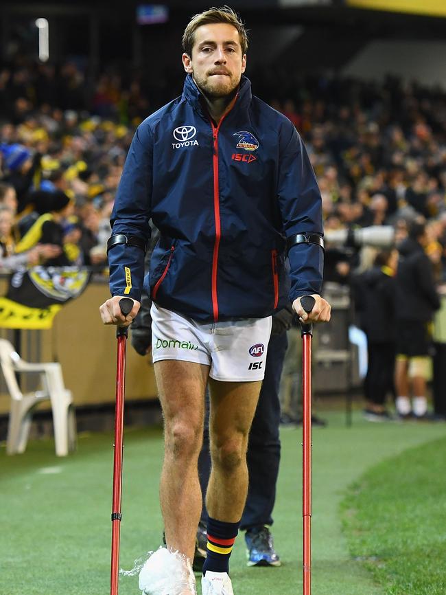 Adelaide’s Richard Douglas on crutches after injuring his ankle during the round 16 AFL match against Richmond at the MCG. Picture: Getty Images