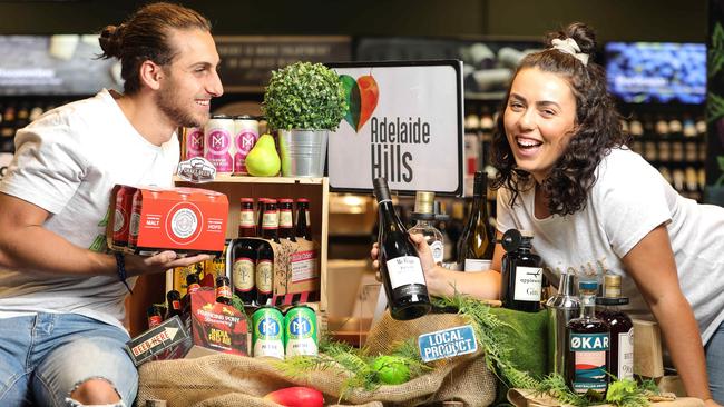 Dion Mignone and Jessica Stefano with a selection of Adelaide Hills wines, beer and spirits at Dan Murphy's Welland. AAP/Russell Millard