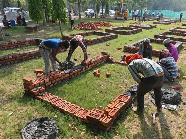 Workers are seen constructing makeshift platforms for funeral pyres inside the premises of a crematorium in New Delhi. Picture: Sajjad HUSSAIN / AFP