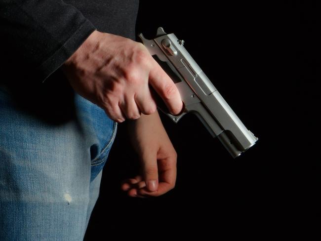 GENERIC PICTURE: Man with a gun in a dark room, man holding gun