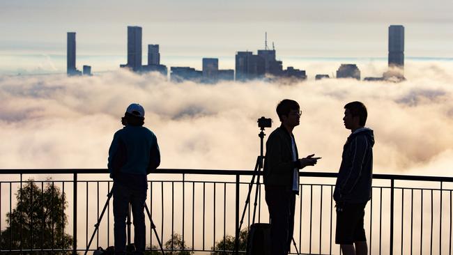 Photographers get some snaps of fog at the Mt Coot-tha summit last month. There are big changes afoot to carparking and a new walking trail. Picture: AAP/Richard Walker