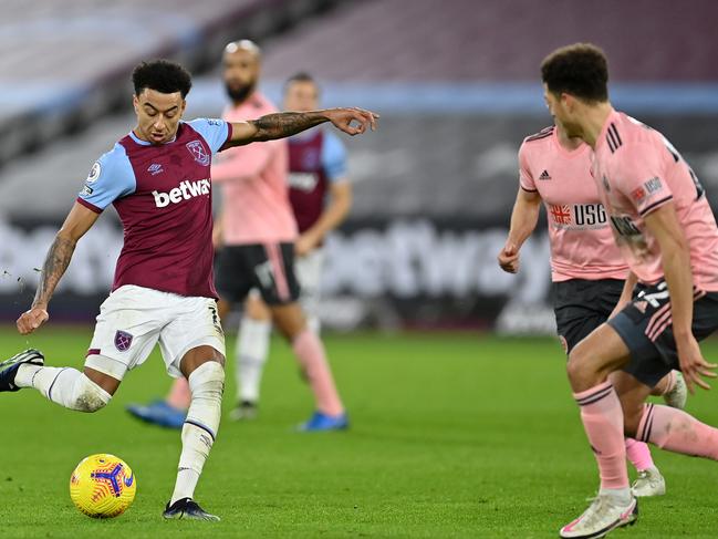 LONDON, ENGLAND - FEBRUARY 15: Jesse Lingard of West Ham shoots under pressure from Ethan Ampadu of Sheffield United during the Premier League match between West Ham United and Sheffield United at London Stadium on February 15, 2021 in London, England. Sporting stadiums around the UK remain under strict restrictions due to the Coronavirus Pandemic as Government social distancing laws prohibit fans inside venues resulting in games being played behind closed doors. (Photo by Justin Setterfield/Getty Images)