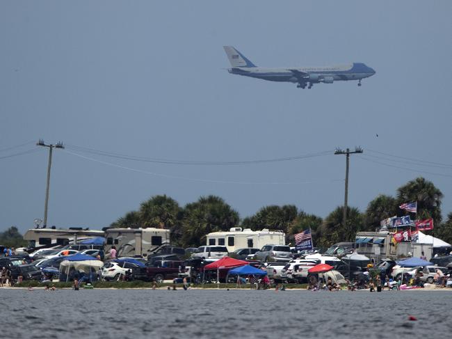 Air Force One carrying President Donald Trump flies past spectators camped in Titusville, Florida, to watch SpaceX Falcon 9 lift off. Picture: AP