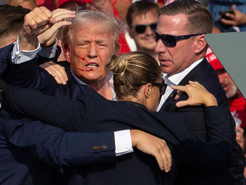 US Republican candidate Donald Trump is seen with blood on his face after surviving an assassination attempt. (Photo by Rebecca DROKE / AFP) / QUALITY REPEAT