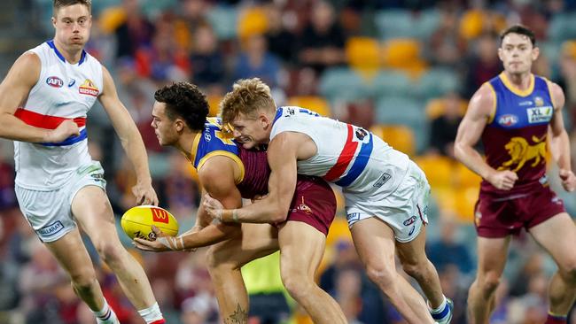 Cam Rayner is tackled by Treloar at The Gabba on Thursday night.