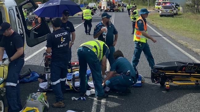 A motorcyclist critically injured in a crash at Burrum Heads on Sunday is treated by paramedics.