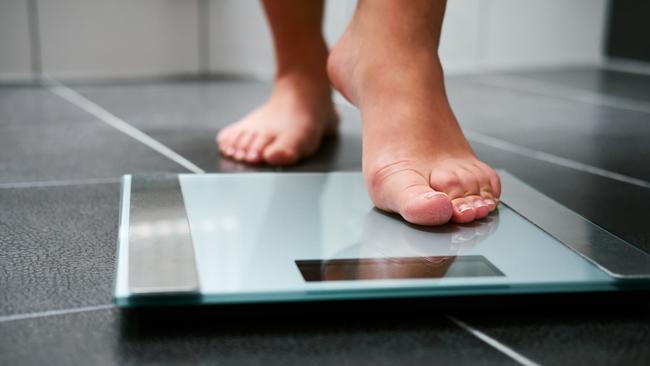 Female bare feet with weight scale in the bathroom, scales generic