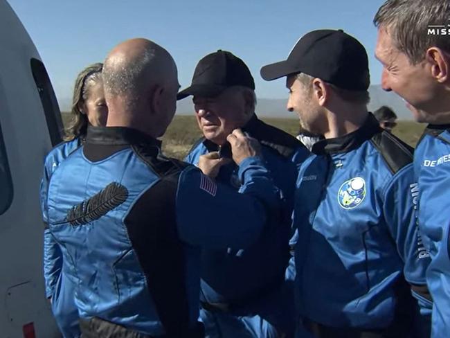 In this still image taken from a Blue Origin video, Blue Origin founder Jeff Bezos awards New Shepard NS-18 mission crew member William Shatner with a pin after the crew landed. Picture: AFP