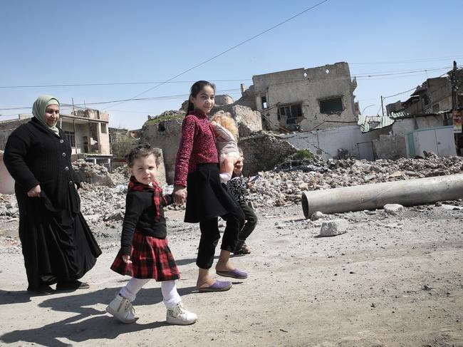 A family heads to buy bread in the Old City in Mosul. Picture: Ella Pellegrini