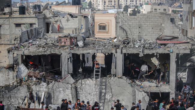 Palestinian citizens carry out search and rescue operations in the destruction caused by Israeli air strikes. Picture: Ahmad Hasaballah