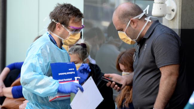 People queue outside the Royal Melbourne Hospital. Picture: Andrew Henshaw