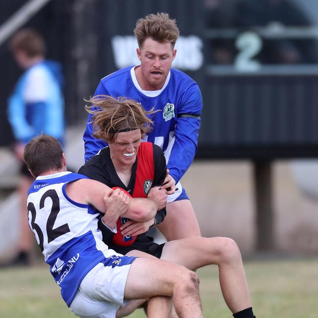 Irrewarra-Beac’s Thomas Swayn is tackled by two South Colac opponents.
