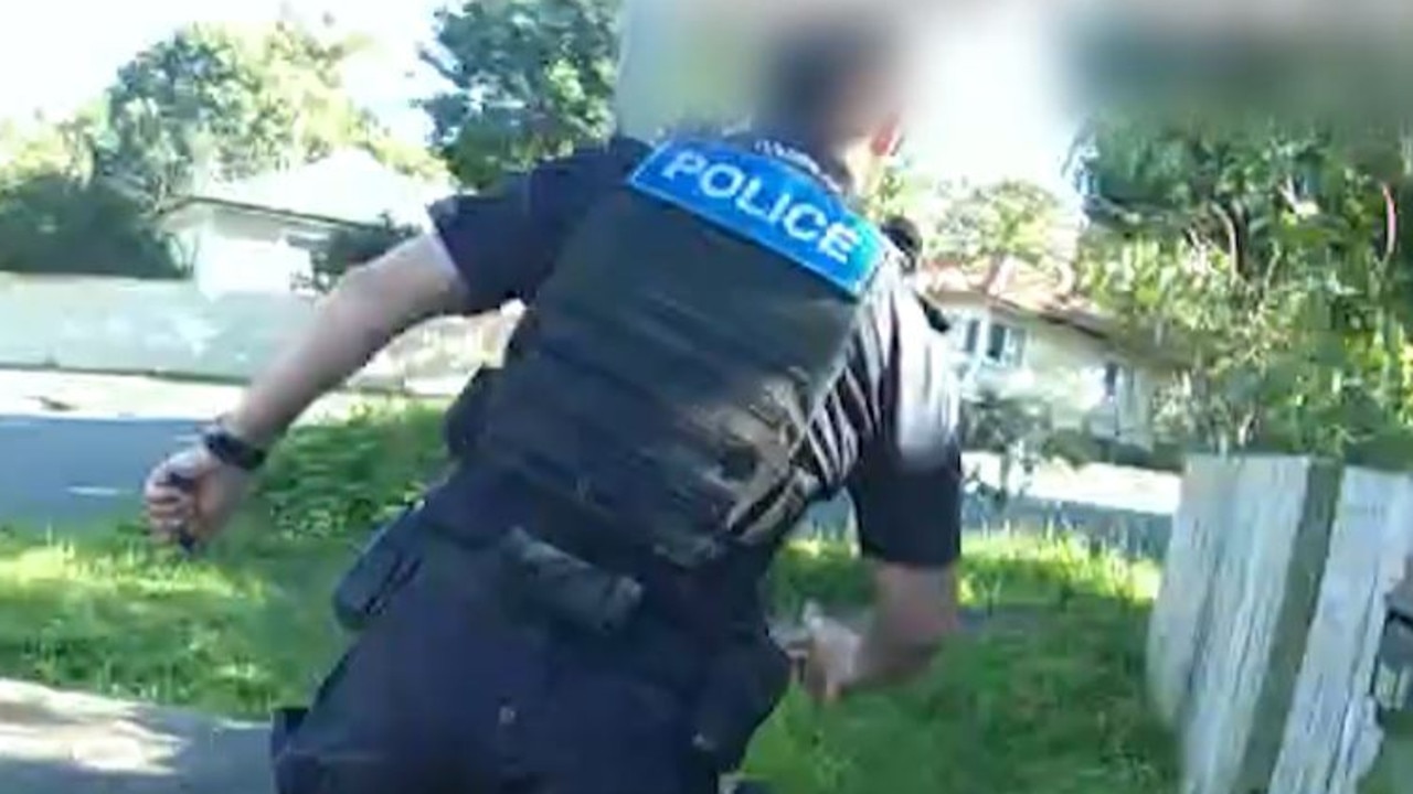 A police officer runs to intercept a teenager accused of a series of break-ins across Brisbane