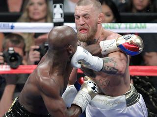 Mixed martial arts star Conor McGregor (R) and boxer Floyd Mayweather Jr. compete during their fight at the T-Mobile Arena in Las Vegas, Nevada on August 26, 2017.  Floyd Mayweather outclassed Conor McGregor with a 10th-round stoppage on August 26 to win their money-spinning superfight and clinch his 50th straight victory. / AFP PHOTO / John Gurzinski