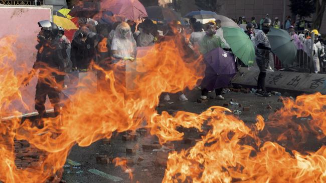 Protesters watch as a fire burns during confrontations with police in Hong Kong using arrows, catapults and molotov cocktails. Picture: AP Photo