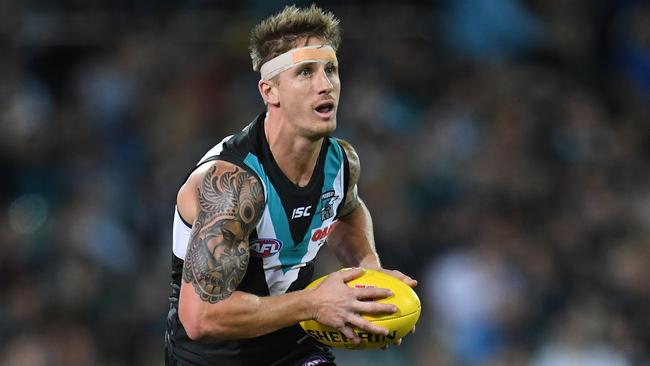 A patched-up Hamish Hartlett runs with the ball on Saturday night. Picture: AAP