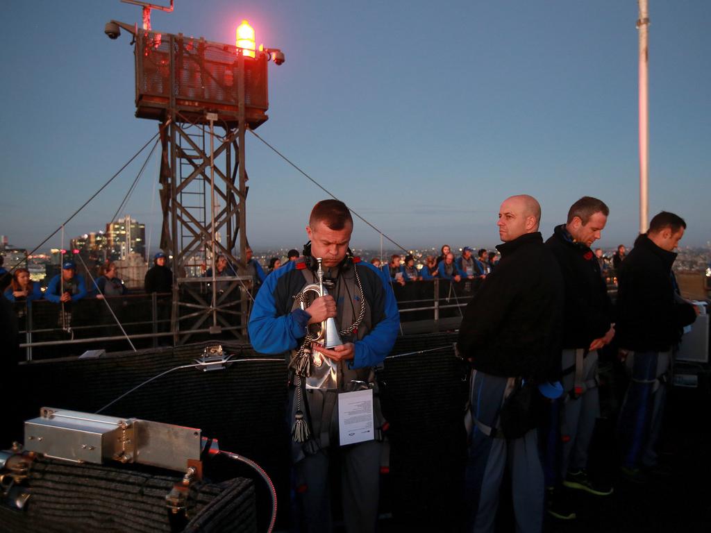 A dawn service was held on the summit of the Sydney Harbour Bridge to commemorate ANZAC Day. Bugler and Leading seaman Marcus Salone gets ready to play The Last Post on top of the bridge, with NRL CEO Todd Greenberg watching on. Picture: Toby Zerna