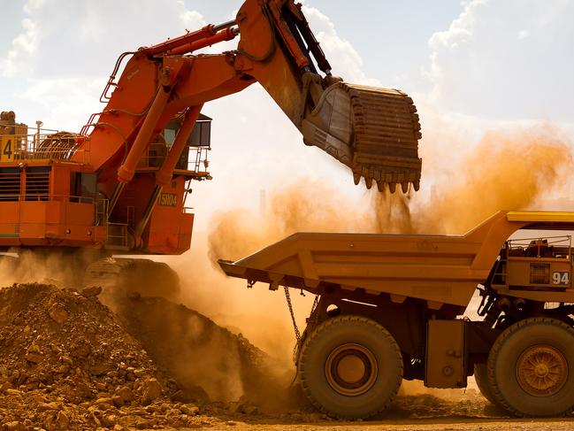 A haul truck is loaded by a digger with material from the pit at Rio Tinto Group's West Angelas iron ore mine in Pilbara, Australia, on Sunday, Feb. 19, 2012. Rio Tinto Group, the world's second-biggest iron ore exporter, will spend $518 million on the first driverless long-distance trains to haul the commodity from its Western Australia mines to ports, boosting efficiency. Photographer: Ian Waldie/Bloomberg