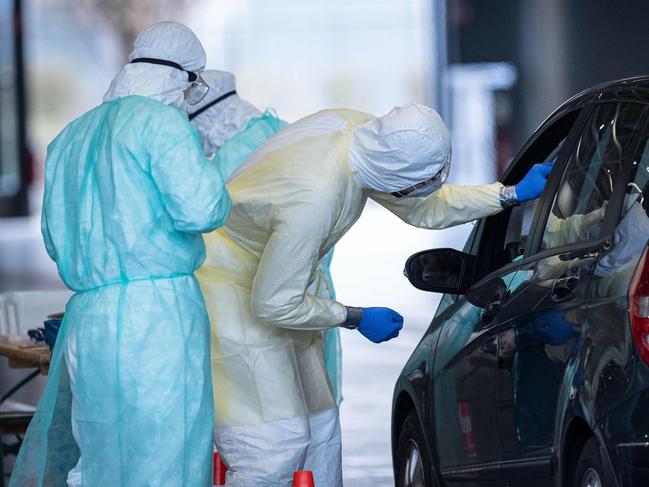 Medical workers take samples at a drive-through testing station. Picture: AFP