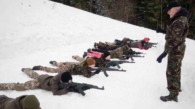 Ukrainian teenagers are taught how to hold a rifle in preparation for a Russian invasion. Picture: Getty Images