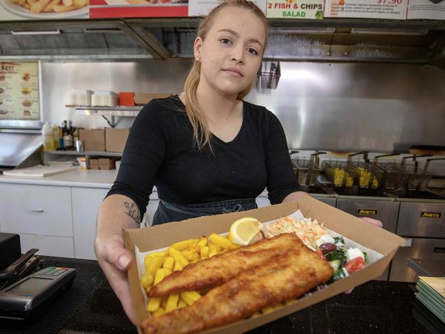 ADELAIDE, AUSTRALIA - Advertiser Photos OCTOBER 27, 2022: Local business worker Teagan Williams 25yrs from Fulham Gardens serving Fish and Chips behind the counter at Captain Chicken and Seafood Henley. Photographer Emma Brasier