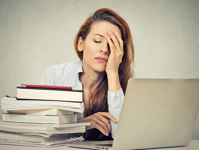 Too much work tired sleepy young woman sitting at her desk with books in front of laptop computer isolated grey wall office background. Busy schedule in college, workplace, sleep deprivation concept