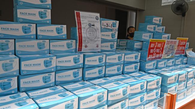 A vendor stands behind stacks of face masks in Singapore. Picture: AFP.