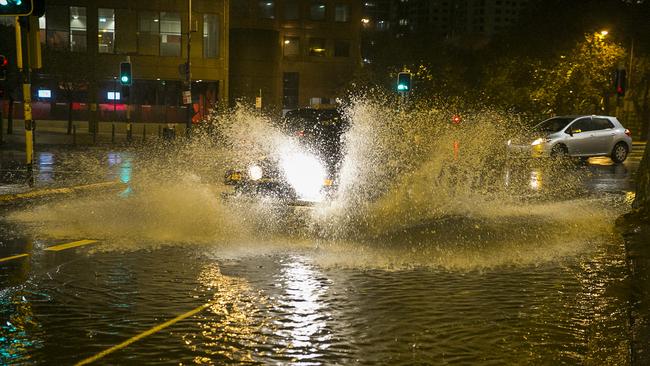 A Jeep splashes through flooding at the intersection of Eddy and Pitt streets in Sydney's CBD overnight. Picture: Chris McKeen