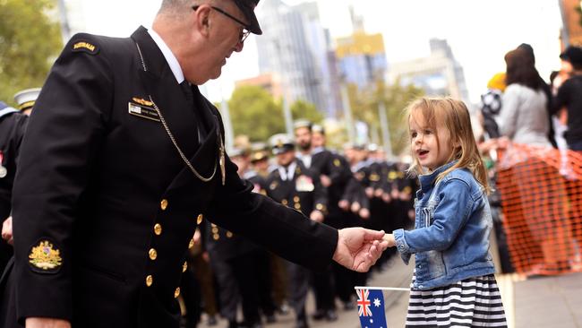 A sailor greets a young girl during the 2018 Anzac Day parade. Picture: AFP