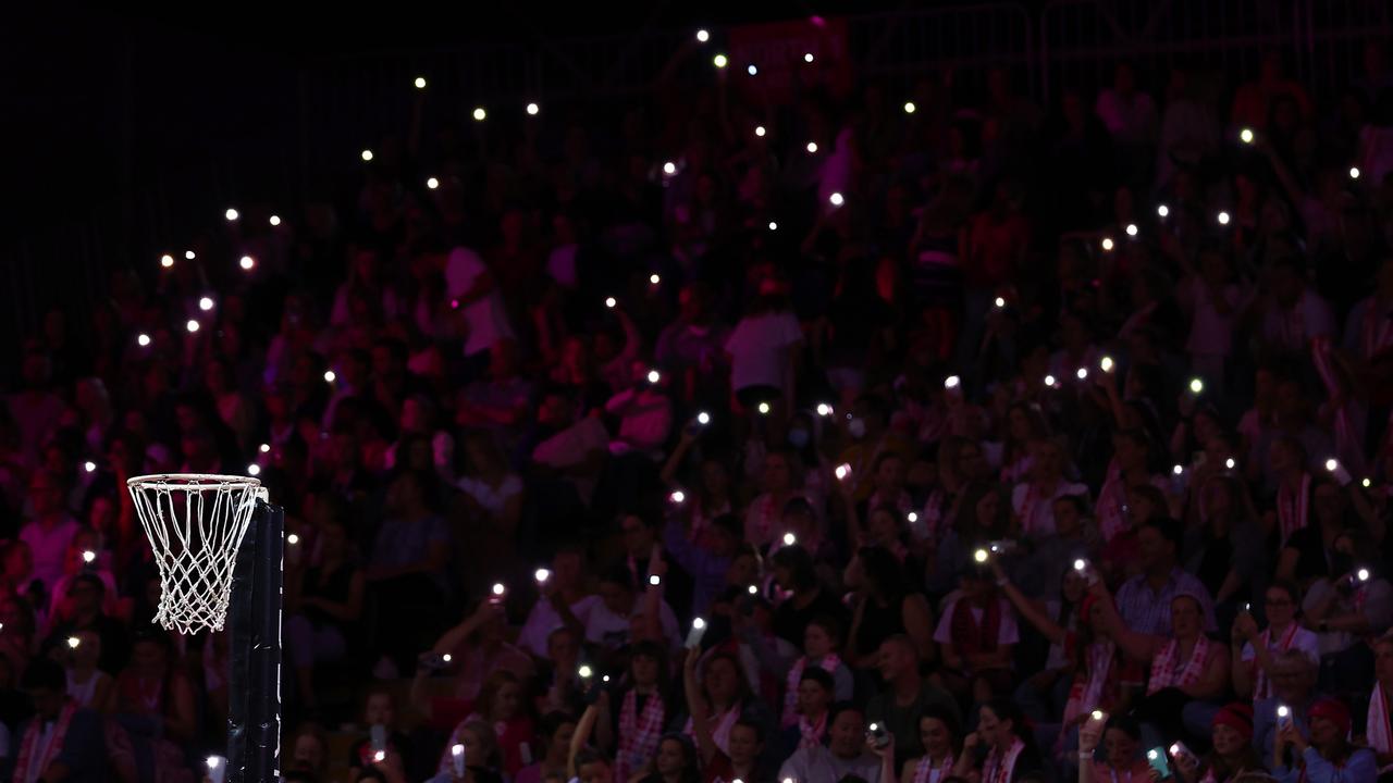 Fans hold torches as a power cut affects Netball SA stadium. (Photo by Graham Denholm/Getty Images)